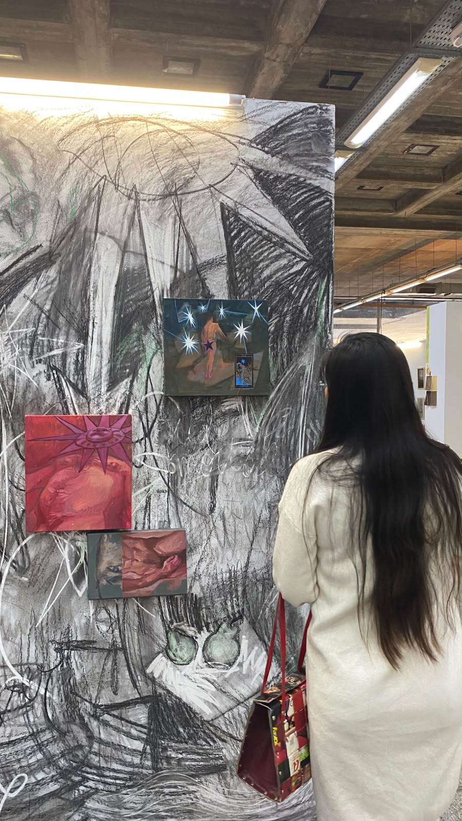 Visitante frente al muro de dibujo y las obras — La Plateada 2026